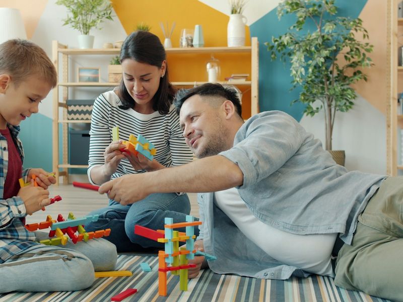 Família brincando com blocos coloridos no chão da sala